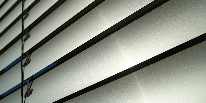 Detailaufnahme einer modernen Außenjalousie mit horizontalen Lamellen.